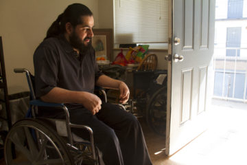 Juan Jose Antonio Deras, an undocumented immigrant from El Salvador, sits in a wheelchair inside the entrance to Casa De Paz. Deras spent three years in a Geo Group immigrant detention center, during which time his health deteriorated rapidly. (Shadowproof / Kevin J. Beaty)