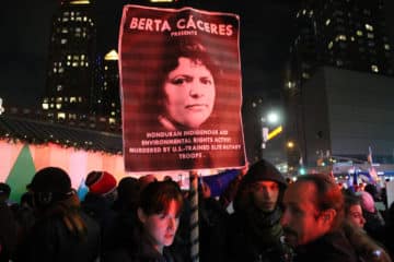 A demonstrator holds a sign recognizing Berta Cáceres at a rally in New York City for Salvador Nasralla, one of two presidential candidates to declare victory after Honduras' presidential election. (Photo by Joe Catron)