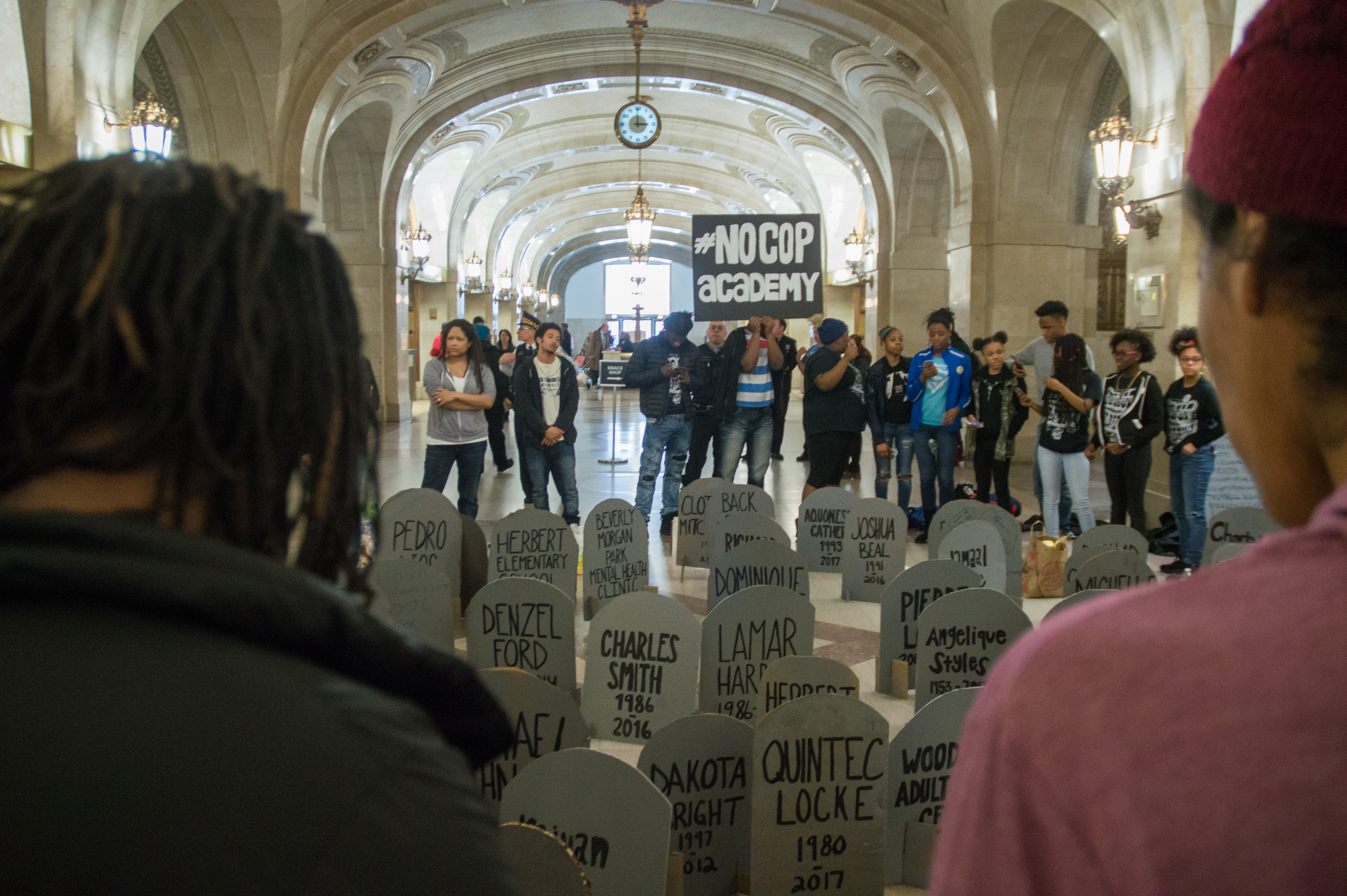 Activists with No Cop Academy set up a makeshift graveyard in Chicago's City Hall with tombstones to represent people killed by the police, and programs shut by the city. Photo by Aaron Cynic.